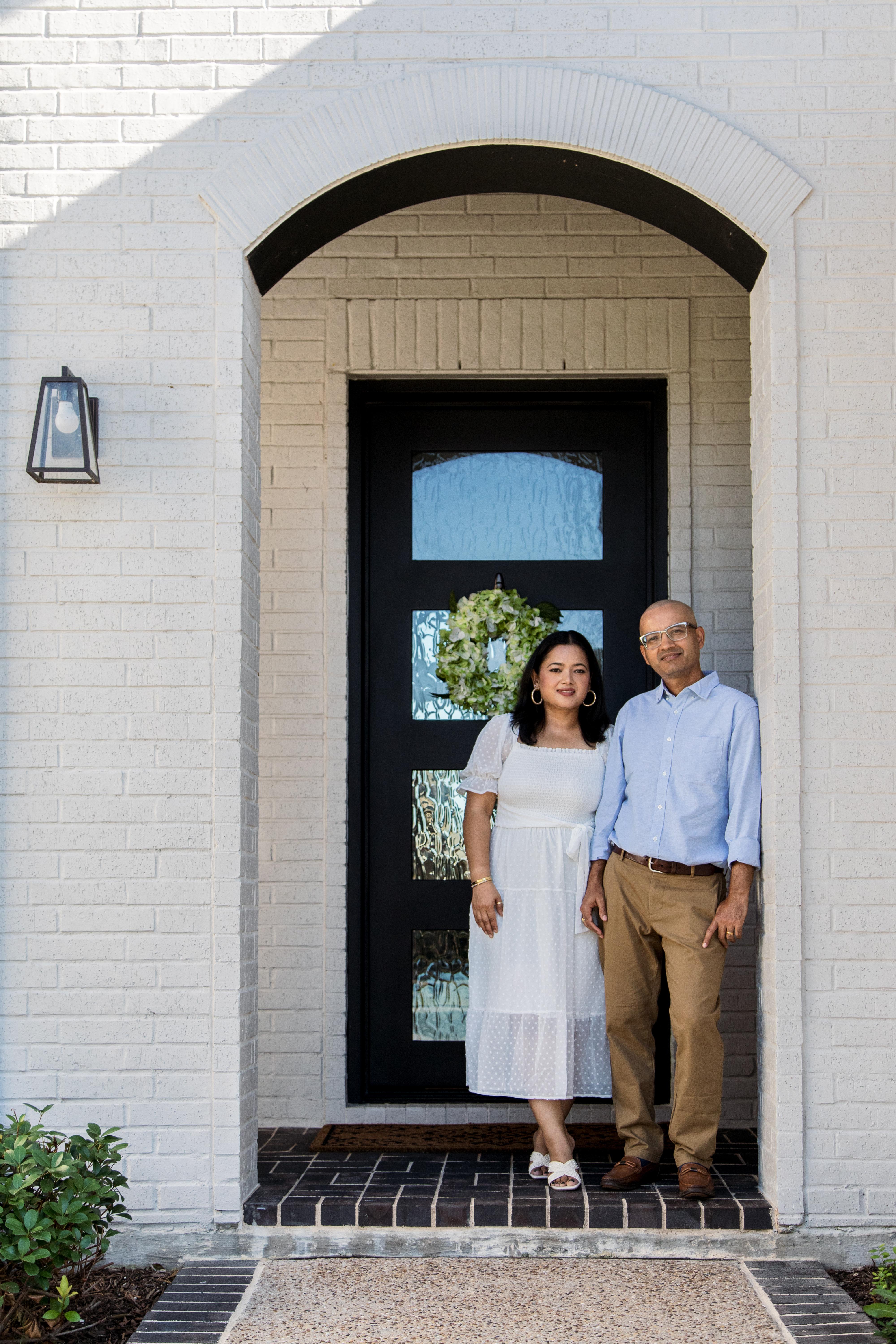 new homeowners stand outside of new custom Drees home